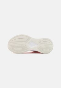 Semelle de chaussure avec une semelle extérieure en caoutchouc blanc texturé présentant des rainures et un accent en forme de diamant au centre, avec un léger dégradé de couleur.