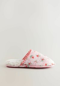 Ziedu raksta čības baltā krāsā ar rozā akcentiem, mīksta vilnas oderējuma, un noapaļota forma. Strukturēta auduma ar mazām dekoratīvām ziediņiem.