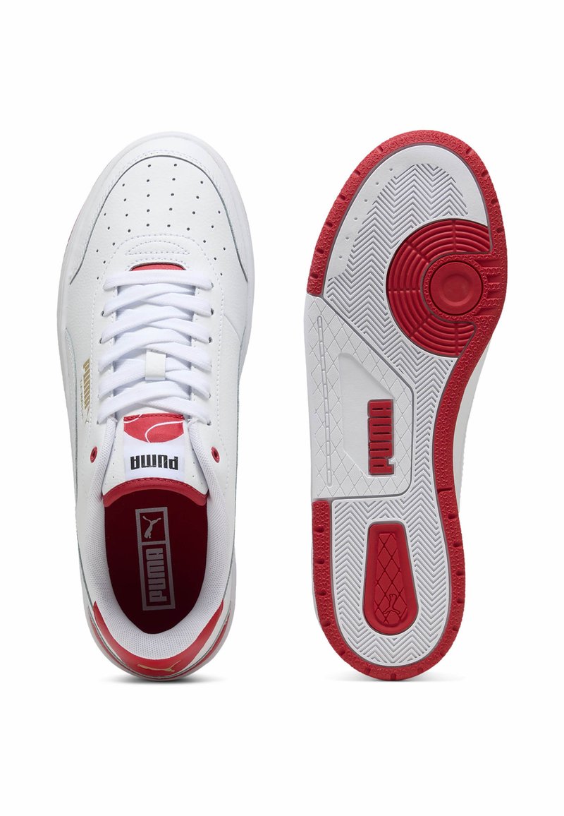 Baskets de sport blanches avec des accents rouges, dotées d'un dessus en cuir lisse, de détails perforés et d'une semelle en caoutchouc texturé.