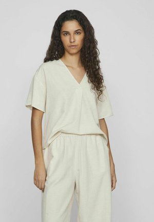Helles Beige, leinenähnliches Kurzarmoberteil mit V-Ausschnitt und lockerer Passform. Kombiniert mit passenden, locker sitzenden Hosen. Weiche Textur und schlichtes Design.