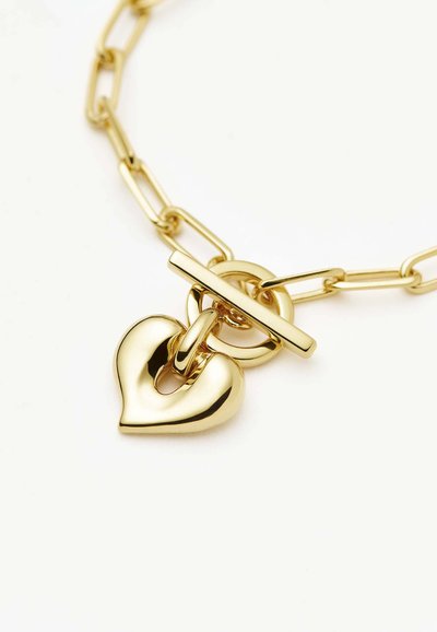 Βραχιόλι αλυσίδα από χρυσό με κούμπωμα τύπου toggle και λαμπερό, λείο πέταλο σε σχήμα καρδιάς σε λευκό φόντο.