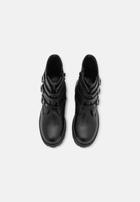 Černé kožené kotníkové boty s hladkým povrchem, s několika detaily na páscích a stříbrnými kovovými akcenty. Kulatá špička a strukturovaná podrážka.