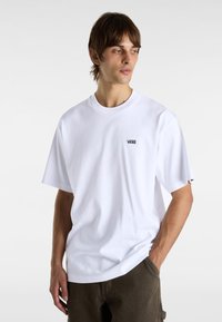 Hvid bomulds t-shirt med rund halsudskæring og korte ærmer, der har et lille sort Vans-logo på venstre bryst.