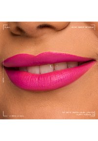 Gros plan sur des lèvres portant un rouge à lèvres mat fuchsia vif à texture lisse, légèrement souriantes pour montrer des dents blanches.