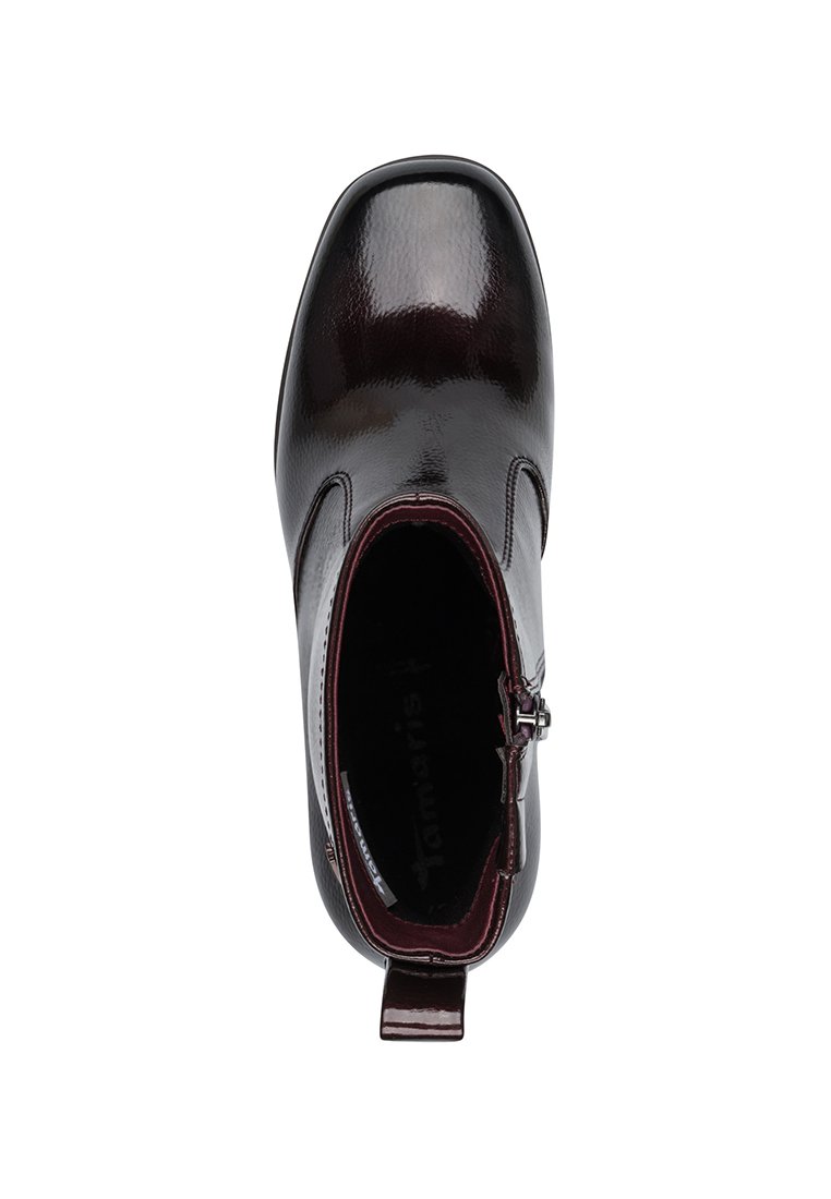 Stivale alla caviglia in pelle verniciata color bordeaux con punta arrotondata, zip laterale e rivestimento interno maroon a contrasto. Texture liscia e lucida.