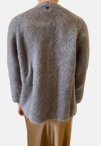 Grauer Wollpullover mit einer weichen, flauschigen Textur, runder Ausschnitt und einem kleinen schwarzen Knopf hinten. Lockere Passform und ärmellange Ärmel.