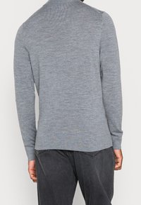 Pull gris à manches longues avec un col côtelé et une texture lisse, doté d'une coupe ajustée et d'un ourlet droit en bas.