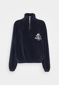 Polaire bleu marine à demi-fermeture éclair, avec poignets et ourlet élastiques, arborant le logo blanc Fiorucci Milan et le motif de jumeaux anges sur la poitrine.
