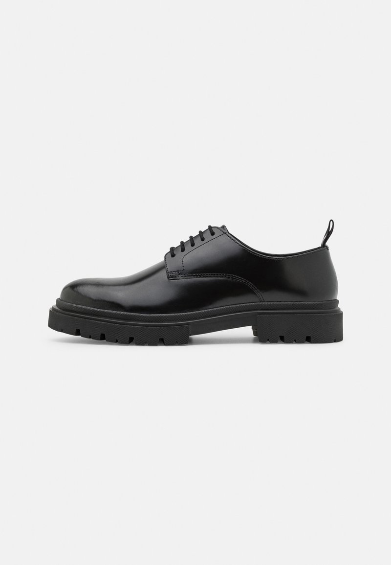 Black leather lace-up shoes with a rounded toe, smooth texture, and ridged rubber sole. Features a small heel and a pull tab at the back.
