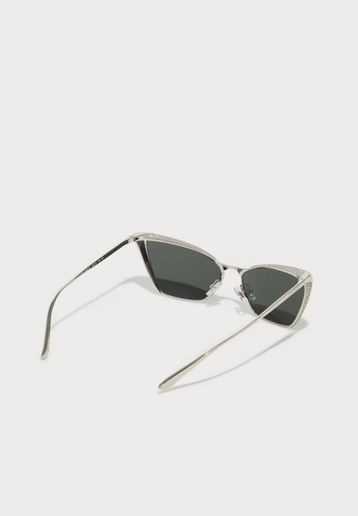 Occhiali da sole a occhio di gatto con lenti nere, montatura in metallo argento e dettagli in cristallo lungo il bordo superiore. Design sottile e angolare.