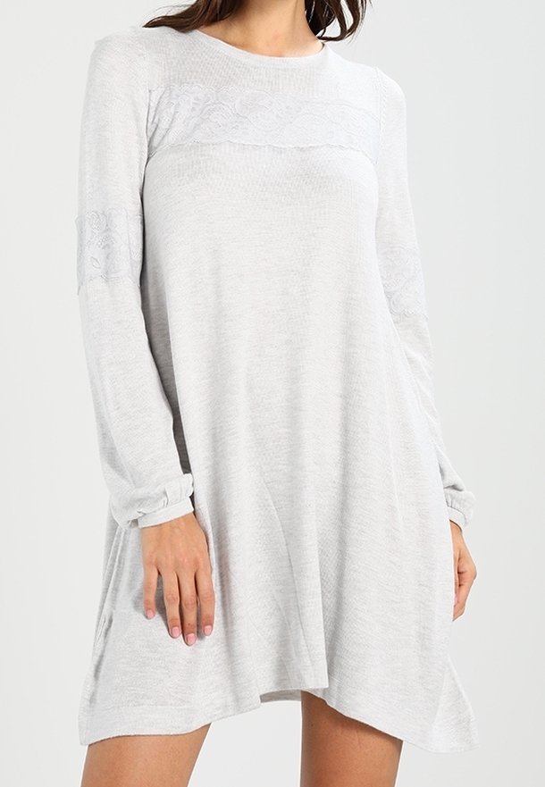 Abito grigio chiaro a maniche lunghe con tessuto strutturato, dettaglio in pizzo sul petto e una silhouette ampia e fluida con spacchi laterali.