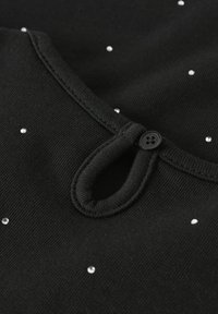 Schwarzer Stoff mit rundem Ausschnitt, verziert mit kleinen silbernen Strasssteinen und einem schwarzen Knopfdetail am Hals. Strukturierte, weiche Oberfläche.