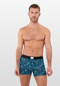 Boxer shorts bleus à motifs avec taille élastique noire, présentant des designs abstraits dans diverses nuances. Tissu lisse et coupe ajustée.