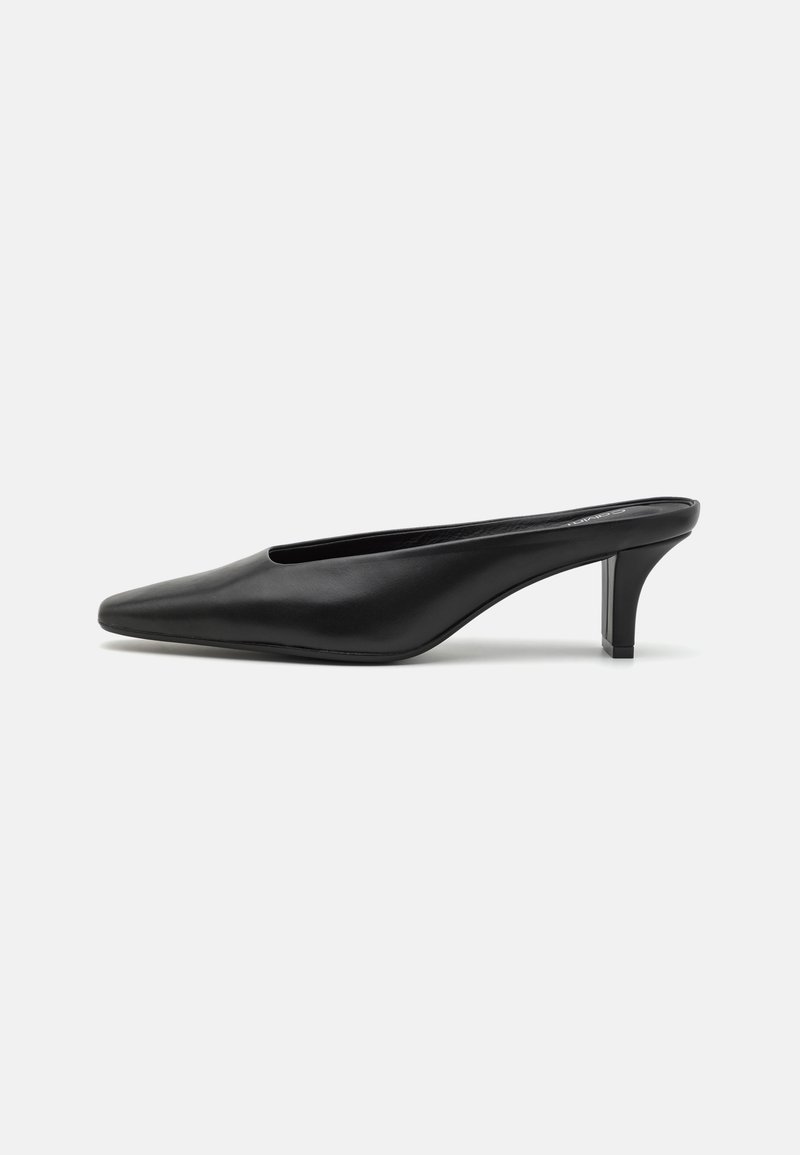Mule-uri negre din piele cu vârful ascuțit și toc stiletto mic. Textură netedă, design minimalist și spate deschis pentru un confort sporit.
