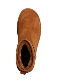Suedes ankelstøvle i varm tan med en blød, faux fur-foring. Har en stikning langs kanten og et rundt tådesignet. Sidelukning for nem påtagning.