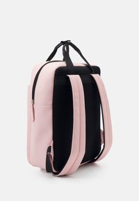 Różowo-czarny plecak z gładkiego materiału przypominającego skórę, o wyprofilowanym kształcie, boczną kieszenią, regulowanymi paskami i zamknięciem na zamek błyskawiczny.