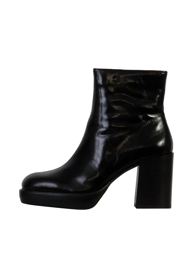Bottine noire avec une finition en cuir brillant, à bout rond et à talon épais. Présente un design lisse et décontracté.