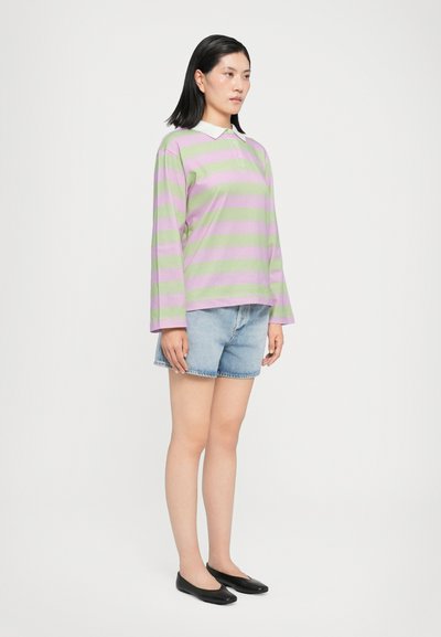 Long-sleeve polo shirt with lavender and green stripes, paired with light denim shorts and black flats.