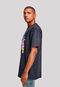 Navy blue cotton t-shirt with short sleeves featuring a multicolored ice cream cone graphic, relaxed fit, and crew neckline.