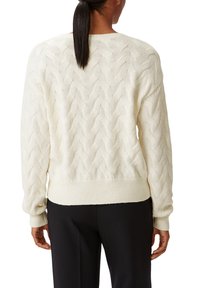 Pull en maille torsadée crème, avec un motif ondulé, bord-côtes aux ourlets et aux manches, coupe décontractée et texture douce. Vue de l'arrière.