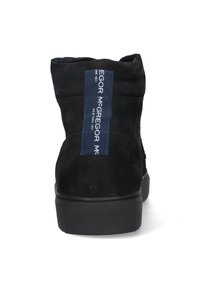 Zwarte leren enkelboot met een gestructureerde rubberen zool, met een blauwe merklabel aan de achterkant en een schoon, minimalistisch ontwerp.