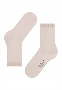 Un paio di calzini crew beige con polsini a coste, uno dei quali mostra il testo della suola "FALKE COSY WOOL" e le informazioni sulla taglia in nero.