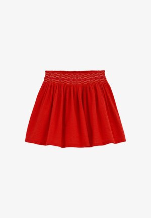 Crvena suknja izrađena od teksturiranog materijala s gumiranim pojasom. Ravnog kroja s naboranim detaljima. Duljina rubova do sredine bedra.