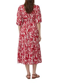 Rode en witte midi-jurk met patroon, met pofmouwen, elastische taille, gelaagde rok en platte sandalen. Heeft een botanische print.