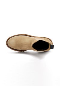Botín de ante beige hasta el tobillo con paneles laterales elásticos y una suela de goma texturizada, con una tira en el talón para facilitar su uso.