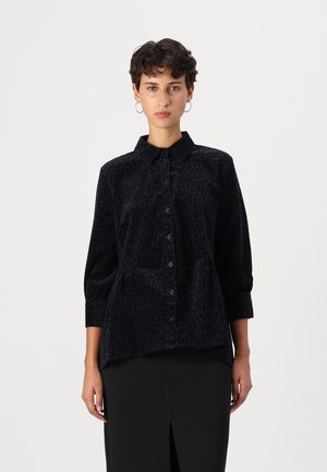 Camicia nera con stampa leopardata, con colletto, maniche lunghe e vita arricciata. Realizzata in tessuto morbido con una finitura testurizzata.