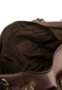 Otwarta brązowa skórzana torba z ciemną podszewką i wewnętrzną kieszonką na zamek oraz etykietą "VENEZIA Genuine Leather".