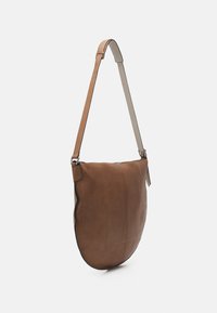 Sac à bandoulière en cuir marron avec une texture lisse, une forme incurvée, une bandoulière réglable et un design minimaliste, présentant des détails de couture subtils.