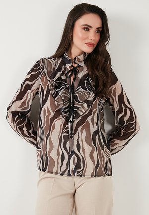 Brown and beige sheer blouse with ruffled collar, black button closures, and a wave pattern. Long sleeves with gathered cuffs.