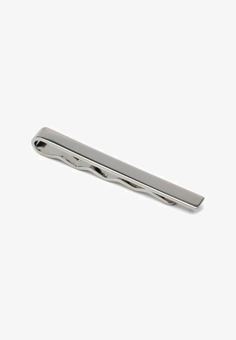 Hopeinen solmionpidike, jossa on tyylikäs, pitkänomainen muotoilu. Yhdessä sivussa on aaltoileva rakenne ja toisella puolella sileä pinta.