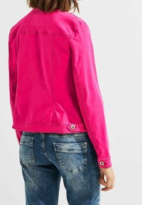Fitted pink denim jacket with long sleeves and a button closure at the waist. Back features stitching details and a classic collar design.