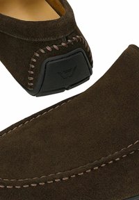 Σκούρο καφέ σουέντ παπούτσι τύπου slip-on με λεπτομερείς ραφές και μαύρο λαστιχένιο τακούνι με διακριτικό λογότυπο.