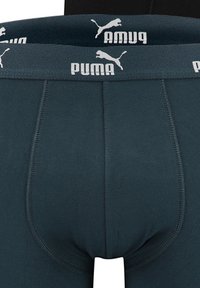 Dunkelblaue Boxer-Briefs mit einem elastischen Taillenbund mit Logo, haben eine enge Passform und eine weiche Stofftextur und zeigen verstärkte Nähte.