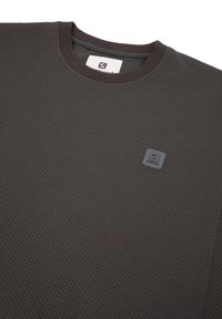 Felpa grigia scura con colletto a costine, tessuto testurizzato con motivo a diamante e un piccolo logo quadrato sul lato sinistro anteriore.
