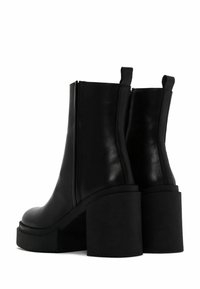 Black leather ankle boots with a high block heel, smooth texture, side zipper, and pull tabs at the top for easy wear.