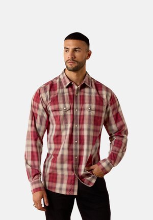 Plaid shirt in red and beige tones, long sleeves, button-up front, featuring chest pockets and subtle textured fabric.