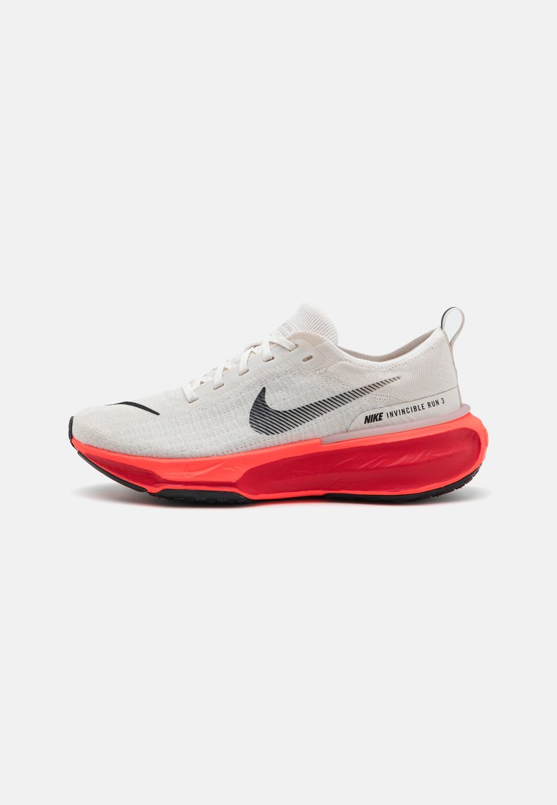 A Nike Invincible Run 3 cipők könnyű, fehér hálós felsőrésze fekete logóval, és egy merész narancssárga hab középtalppal rendelkezik, amelyhez texturált fekete külső talp társul.