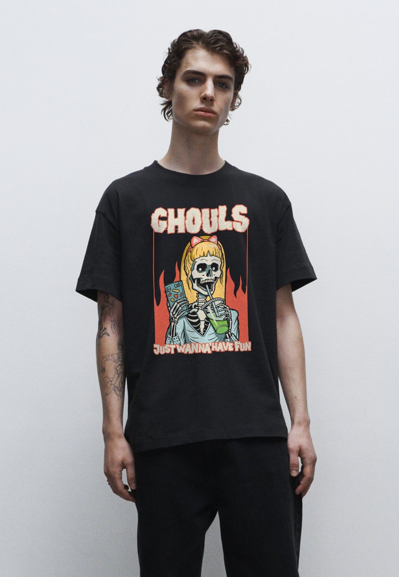 Černé bavlněné tričko s barevným potiskem kostlivce a textem "GHOULS JUST WANNA HAVE FUN", kulatý výstřih a krátké rukávy.