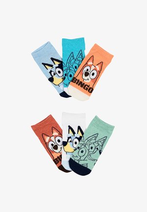 Zes kleurrijke paren kindersokken met cartoon hondengezichten in verschillende kleuren, gerangschikt in twee rijen op een witte achtergrond.