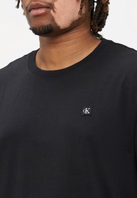 Calvin Klein Jeans Plus PLUS EMBRO BADGE TEE - Lihtne T-särk - black