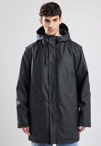 Parka impermeabile nera con chiusura anteriore a bottoni, cappuccio con cordino regolabile e tasche laterali. Tessuto liscio, design lungo fino al ginocchio.