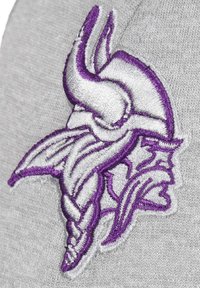 Grauer Stoff mit einem auffälligen, weiß und lila gestickten Design eines Wikingerhelms, das über feine Details und sichtbare Textur verfügt.