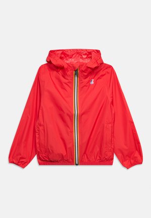 Veste légère à capuche rouge avec fermeture éclair à l'avant, ornée de bandes noires, blanches et jaunes, deux poches latérales, poignets et ourlet élastiques.