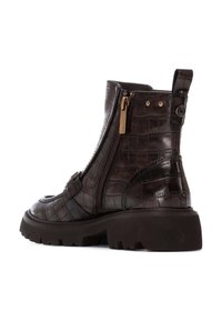 Brązowe, teksturowane skórzane botki sięgające kostki z wzorem krokodyla, zamkiem błyskawicznym z boku oraz masywną podeszwą zapewniającą przyczepność. Posiadają pętelkę do zakładania oraz akcenty w złotym kolorze.