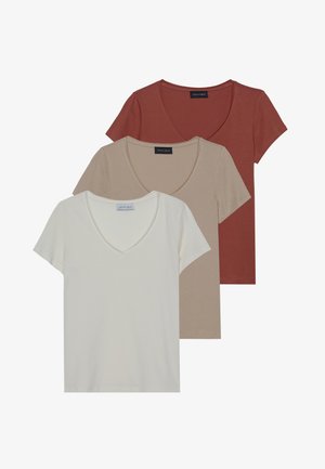 Trois t-shirts à manches courtes en v en rouge, beige et blanc. Tissu doux avec une texture lisse, chacun affiche une étiquette au niveau du col.