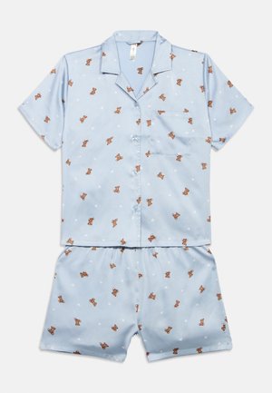 Sæt med lys blå kortærmet skjorte med knapper og shorts med små brune bamse- og hvide hjerteprints samt brystlomme.